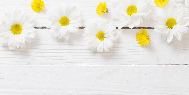 white chrysanthemum and yellow coltsfoot on white wooden background - Zdjęcie, obraz