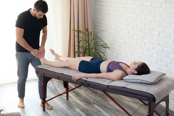 Giovane donna ottenere massaggio seesion a casa da un fisioterapista
. - Foto, immagini