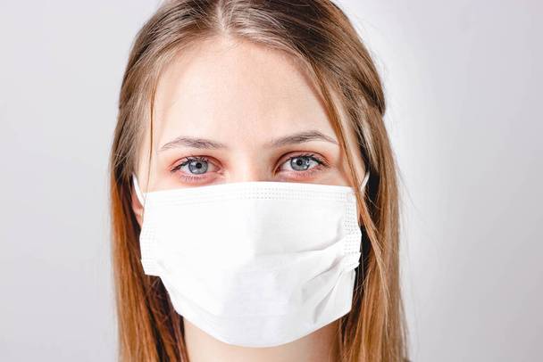 Γυναίκα με ιατρική μάσκα στο πρόσωπο. Προστασία από ιούς και λοιμώξεις. Μείνε σπίτι, Κορόνα.. - Φωτογραφία, εικόνα