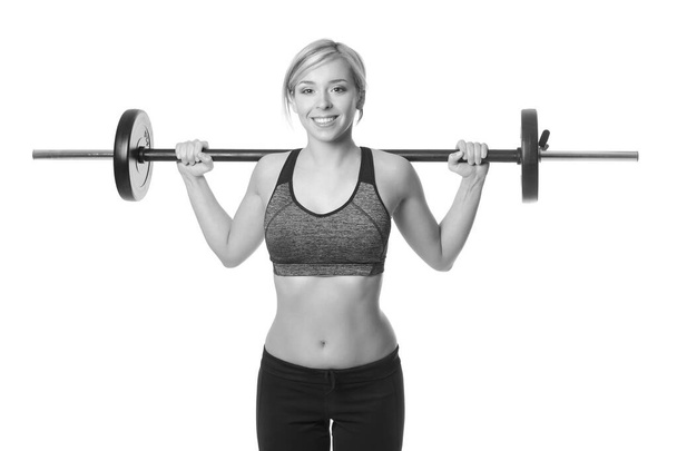 smiling sporty woman exercising with barbell on a white background - Zdjęcie, obraz