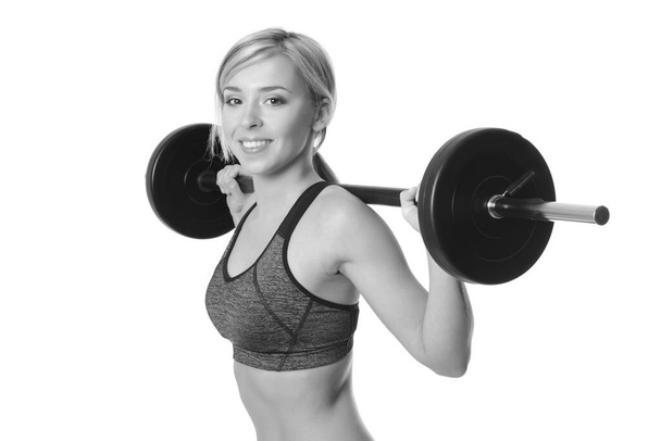 smiling sporty woman exercising with barbell on a white background - Photo, Image