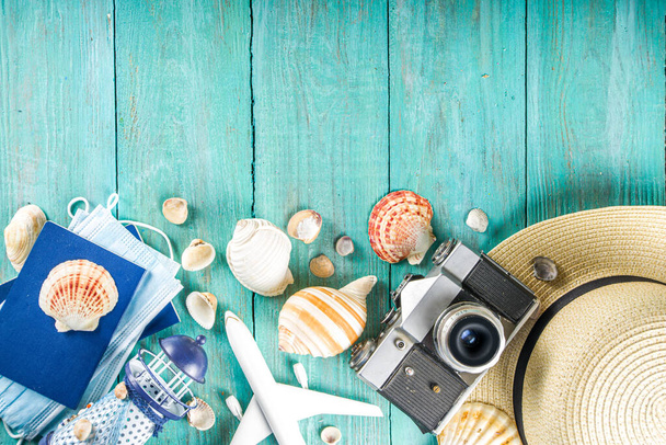 Luminoso fondo plano de verano. Antiguo fondo de madera azul con ropa de mujer de verano, gafas de sol, sombrero, cámara, pasaportes y boletos de vacaciones
 - Foto, Imagen