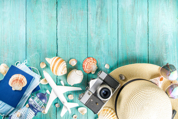 Bright  summer flat-lay background. Old blue wooden background with with summer woman clothes, sun glasses, hat, camera, passports and vacation tickets - Photo, Image