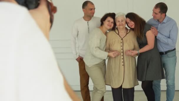 Valokuvaaja ottaa kuvia vanhasta naisesta lastenlastensa kanssa
 - Materiaali, video