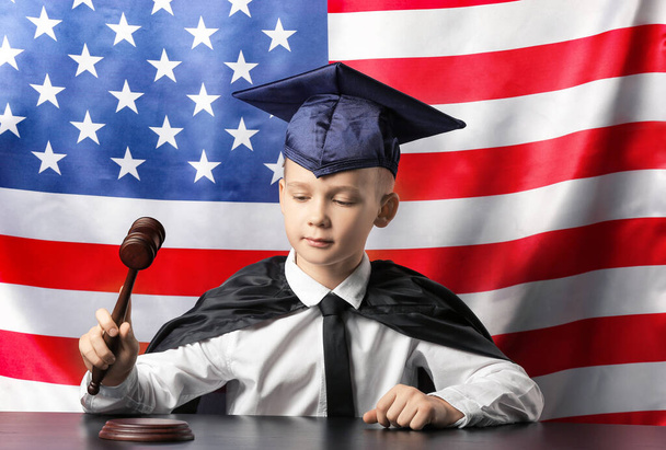 Little judge sitting at table with national flag of USA on background - Photo, Image