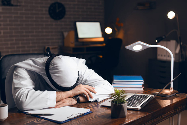 Сплячий азіатський бізнесмен в офісі пізно вночі. - Фото, зображення
