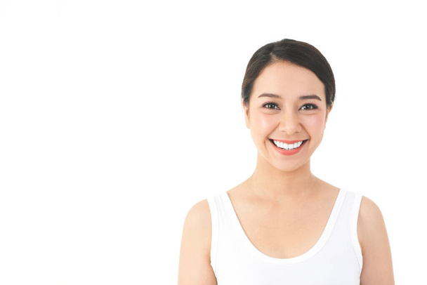 Una mujer asiática con una hermosa y joven sonrisa y buena piel. Limpio y saludable. Concepto de belleza. con espacio para copias. Fondo blanco - Foto, imagen