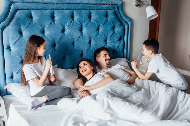 Lovely,young family  lying with children in the bedroom. Family concept.. - Foto, Bild