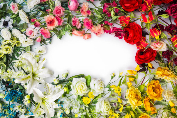 Κάτοψη στρογγυλής κορνίζας με διακόσμηση τεχνητών λουλουδιών, κλαδιών, φύλλων, πέταλων, οργάνων και χρωμάτων. απομονωμένο σε λευκό φόντο. - Φωτογραφία, εικόνα