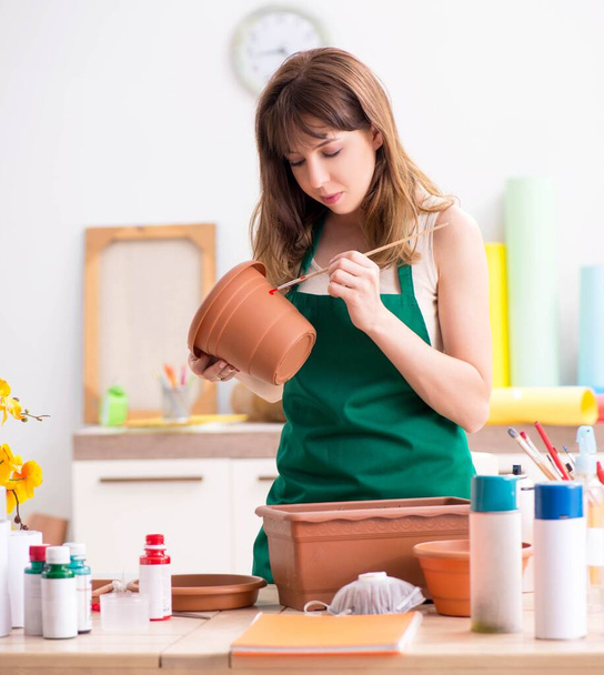 Молодая женщина украшает керамику в мастерской
 - Фото, изображение