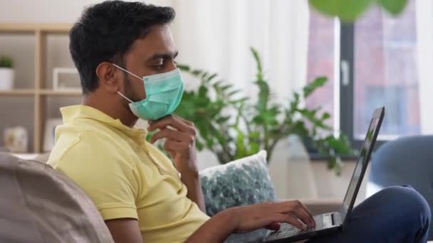 indian man in mask with laptop at home office - Πλάνα, βίντεο