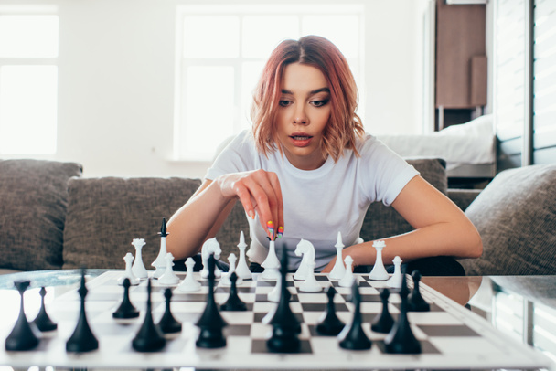 attractive girl playing chess on self isolation, selective focus - Foto, Bild