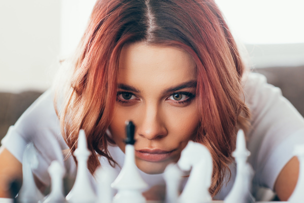 συμπυκνωμένο όμορφο κορίτσι παίζει σκάκι για την αυτο απομόνωση, επιλεκτική εστίαση - Φωτογραφία, εικόνα