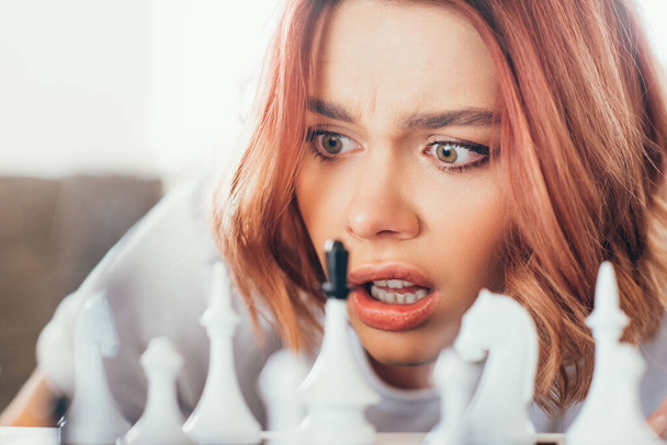 zdezorientowana dziewczyna gra w szachy na samokontroli, selektywne skupienie - Zdjęcie, obraz