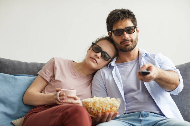 Portret nowoczesnej pary oglądającej razem telewizję, siedzącej na sofie i noszącej okulary stereo w domu, cieszącej się leniwym czasem, przestrzeń do kopiowania - Zdjęcie, obraz