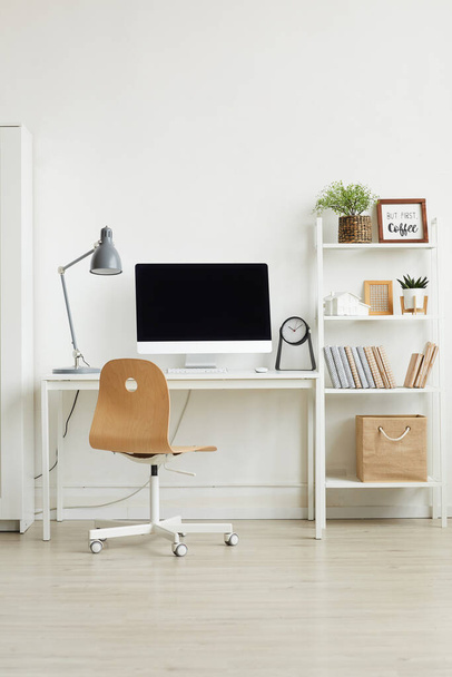 Фон Вертикальне зображення тла мінімального інтер'єру домашнього офісу з дерев'яним стільцем та білим комп'ютерним столом на білій стіні, простір для копіювання
 - Фото, зображення