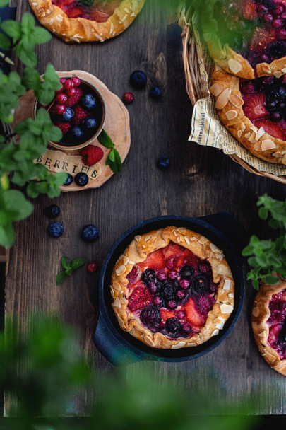 Summer homemade pastry, galette with berries on rustic wooden background, top view - Fotografie, Obrázek