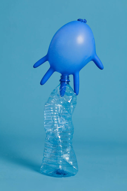 Vista completa en botella de plástico desechada disparada en el estudio contra fondo azul, clasificación de residuos y concepto de reciclaje
 - Foto, Imagen