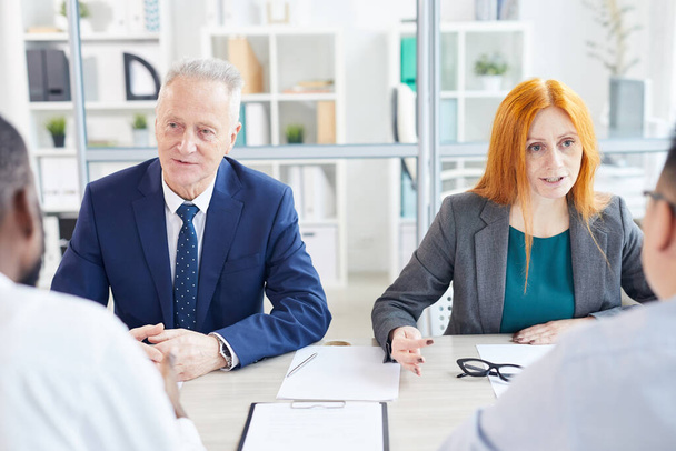 Portrait of two business people interviewing candidates for job position in modern office - Fotoğraf, Görsel