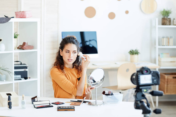 Joven adulto caucásico mujer haciendo casual maquillaje y proceso de grabación en la cámara
 - Foto, Imagen