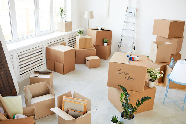 Wide angle background image of stacked cardboard boxes in empty room, moving, relocation and house decor concept, copy space - Photo, Image
