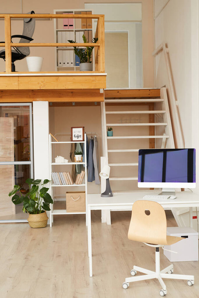 Вертикальное фоновое изображение современного двухуровневого офисного пространства с компьютерным столом на переднем плане, копировальное пространство - Фото, изображение