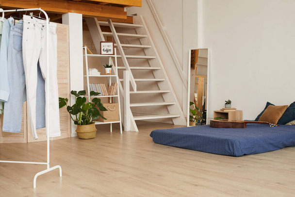 Background image of minimal bedroom interior with low bed and wooden flooring, copy space - 写真・画像
