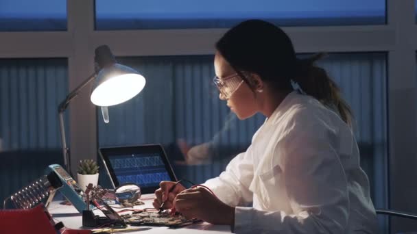 Ingegnere elettronico femminile che lavora con tester multimetro e altri dispositivi elettronici in laboratorio
 - Filmati, video