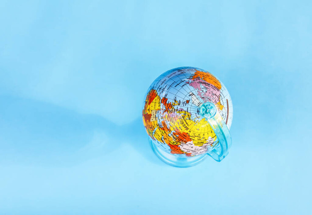 Small globe on blue background. - Photo, Image