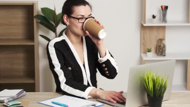 Attraente donna d'affari che lavora sul computer portatile nella sua postazione di lavoro
. - Filmati, video