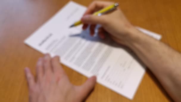 Un jeune homme signe un document avec un stylo
 - Séquence, vidéo
