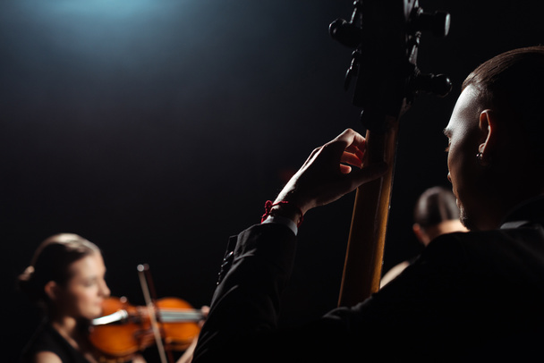 három hivatásos zenészek játszanak hangszerek sötét színpadon - Fotó, kép