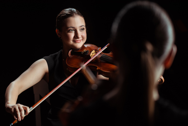 músicos profissionais felizes tocando música clássica em violinos no palco escuro
  - Foto, Imagem