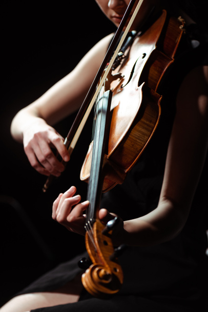 partial view of musician playing symphony on violin isolated on black - Фото, зображення