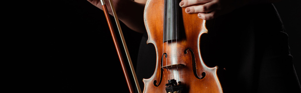 partial view of professional musician holding violin isolated on black, panoramic concept - Photo, Image