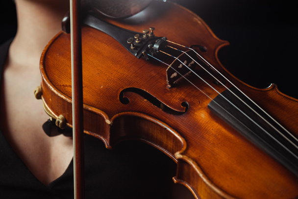 μερική άποψη του γυναικείου μουσικού που παίζει συμφωνική σε βιολί απομονωμένο σε μαύρο - Φωτογραφία, εικόνα