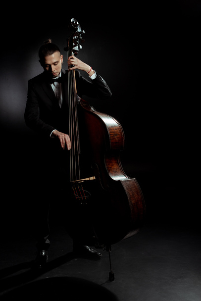 profi férfi zenész játszik contrabass sötét színpadon - Fotó, kép