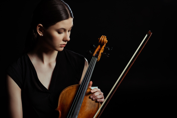 beautiful female musician holding violin isolated on black - Foto, Imagen