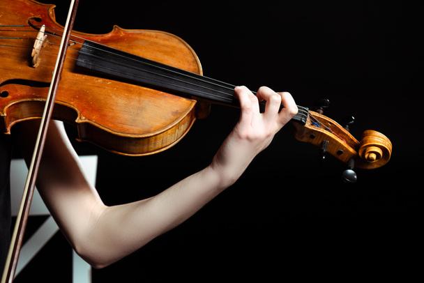 ostříhaný pohled na ženskou muzikantku hrající na housle izolované na černém - Fotografie, Obrázek