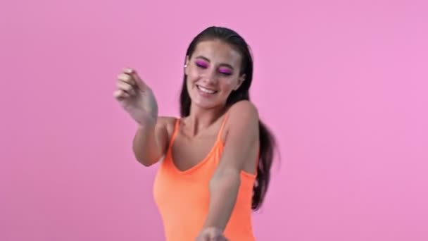 Young amazing happy positive woman isolated over pink wall background dancing - Imágenes, Vídeo