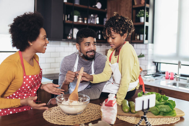 Happy family preparing healthy food in kitchen together - Photo, Image