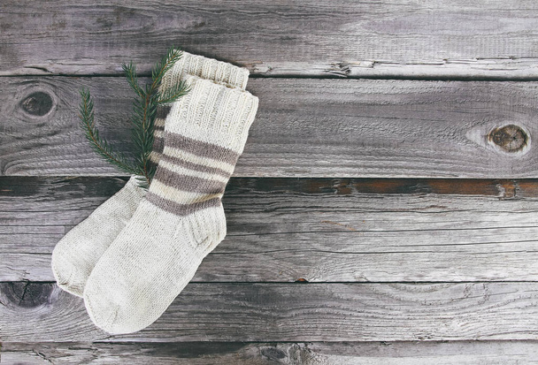 Kézzel készített meleg kötött zokni gyapjúfonalból, fából készült durva alapon. - Fotó, kép
