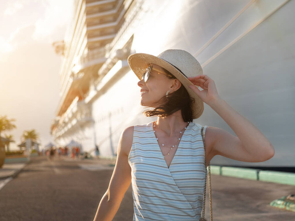 Boldog fiatal nő a háttérben egy fehér hajó a kikötőben - Fotó, kép