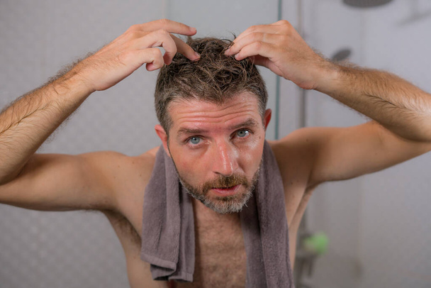 retrato do estilo de vida do adulto médio atraente preocupado e chateado homem em casa de banho procurando e encontrando cabelos grisalhos olhando para o espelho preocupado com o envelhecimento
  - Foto, Imagem