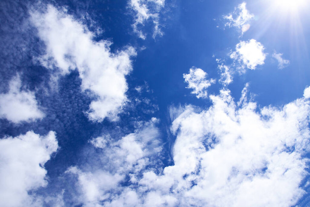 Μπλε ουρανό φόντο με λευκά αφράτα σύννεφα σε ζεστή καλοκαιρινή μέρα. - Φωτογραφία, εικόνα