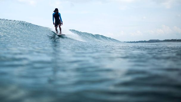 surfer rides a wave on beautiful bali - Фото, зображення