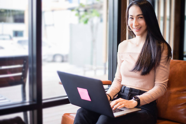 Азійські бізнесмени використовують ноутбуки для роботи з дому. Вона посміхається і любить працювати.. - Фото, зображення