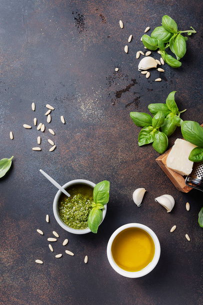 Traditional Fresh Italian pesto with basil, pine nuts, cheese and oil on the black background. Top view image with a copy space - Valokuva, kuva