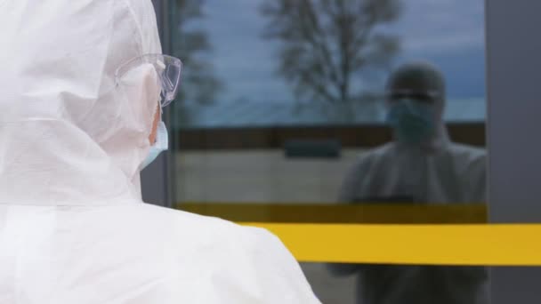 healthcare worker sticking biohazard sign to door - Πλάνα, βίντεο