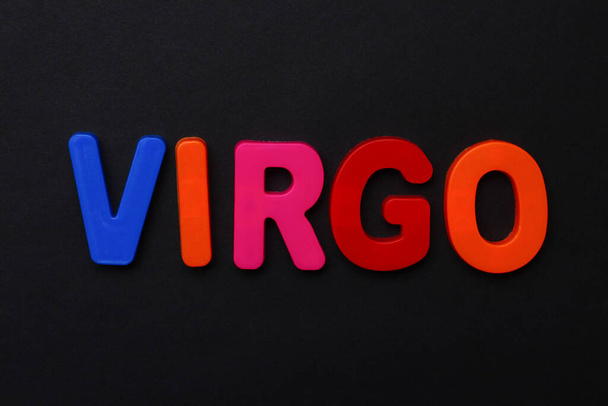 Virgo text. Zodiac sign written in bright multi-colored cheerful letters on a black dramatic background. Low dark key. Horoscope Theme - Photo, Image